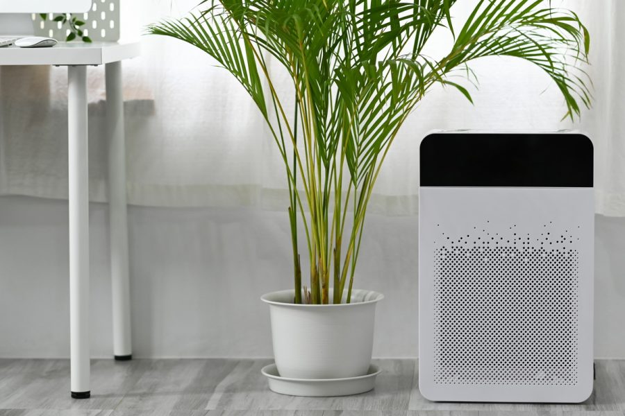 Modern air purifier on n floor in bright living room for filter and cleaning removing dust PM2.5.